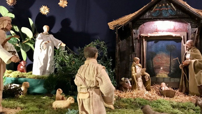 Komplexe Weihnachtskrippe mit der Darstellung der Geburt Jesu, traditionellen Figuren und Tieren in einem rustikalen Stall.