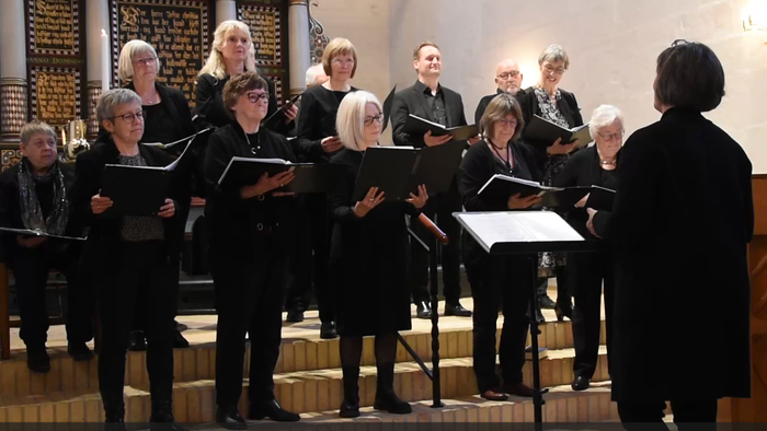 En kor sang i kirke med dirigent.