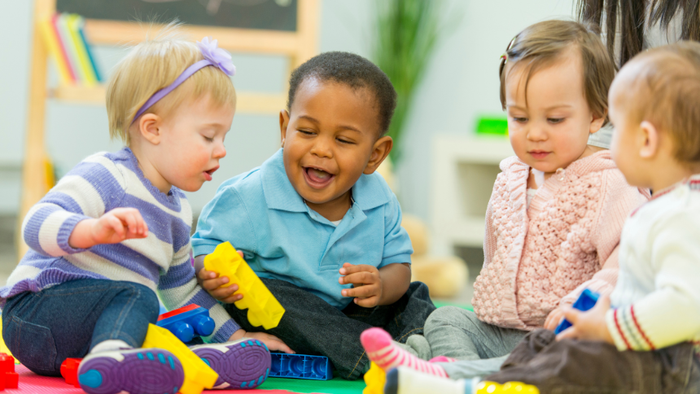 Kinder, die in einem Klassenzimmer mit Spielzeug spielen.
