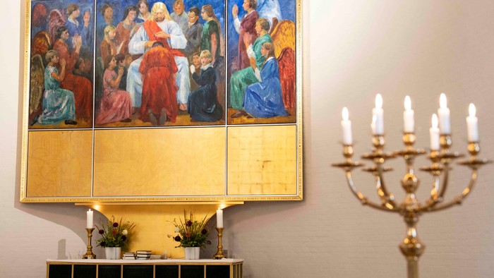 Billedet viser alter med religiøs maleri og gylden kandleholder