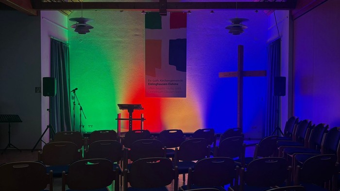 Farbenfrohe Kirche mit bunten Lichtern und Stühlen