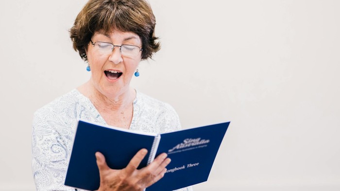 Singende Seniorin mit Liedheft