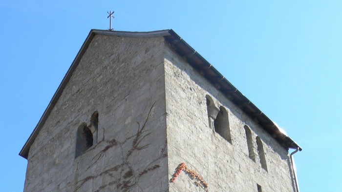 Hoher Steinturm mit Efeu, der daran wächst.