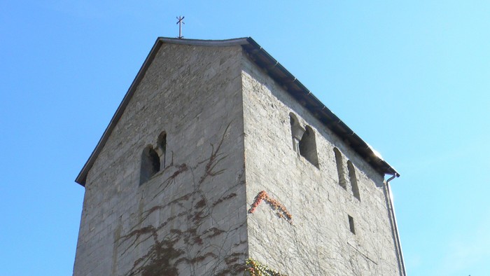 Hoher Steinturm mit Efeu, der daran wächst.
