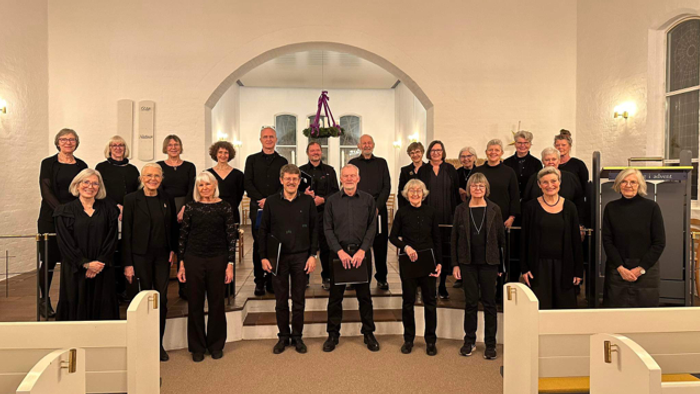 En gruppe korister poser i en kirke