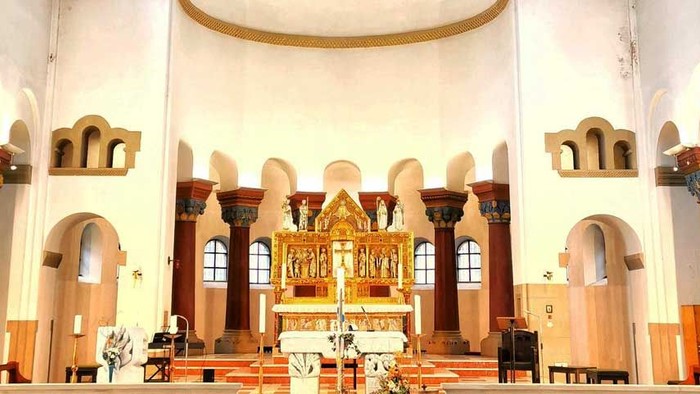 Innenraum einer Kirche mit Kreuz und Kirchenbänken