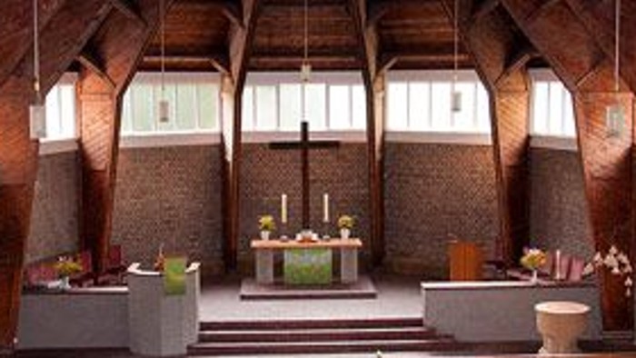 Innenraum einer Kirche mit Holzstühlen und hohem Gewölbe