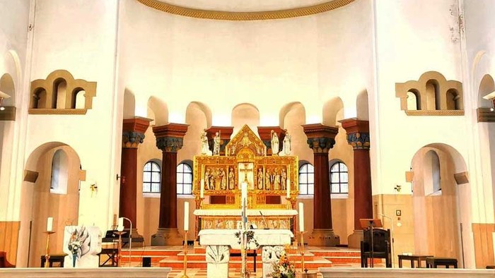 Innenraum einer Kirche mit Kreuz und Kirchenbänken