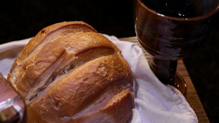 Ein Glas Rotwein und ein Stück Brot auf einem Tisch