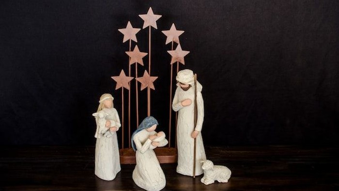 Die Figurengruppe stellt eine Krippe mit Maria, Josef und Baby Jesus dar, umgeben von Sternen.