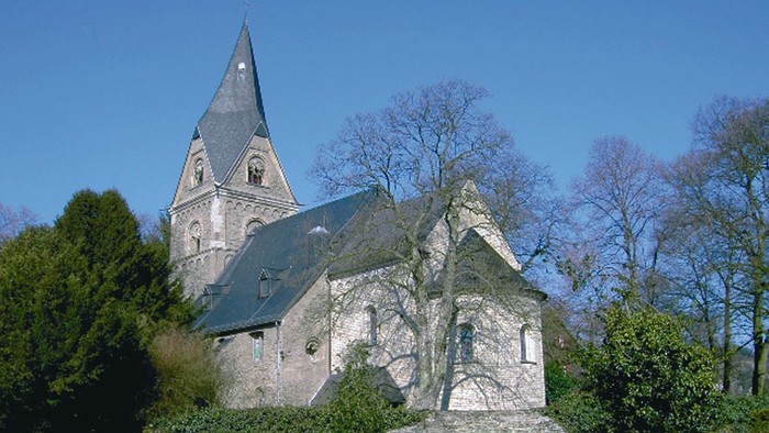 Alte Kirche mit hohem Turm und umgebendem Friedhof