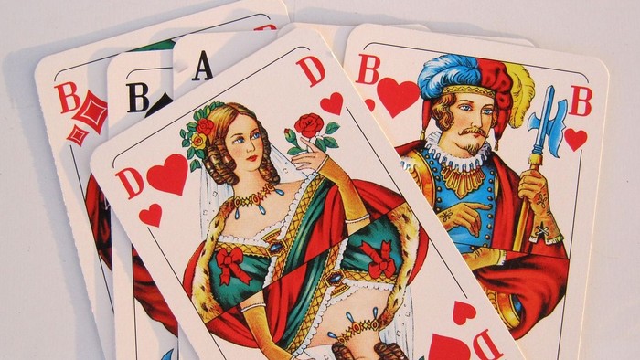 Ein Kartenspiel mit traditionellen Hofkarten und nummerierten Karten mit roten Herzsymbolen.