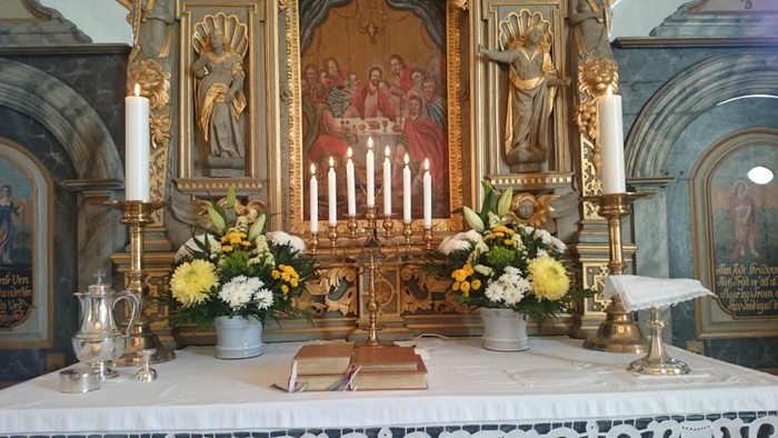 Altaret i kirken med blomster og lysestage