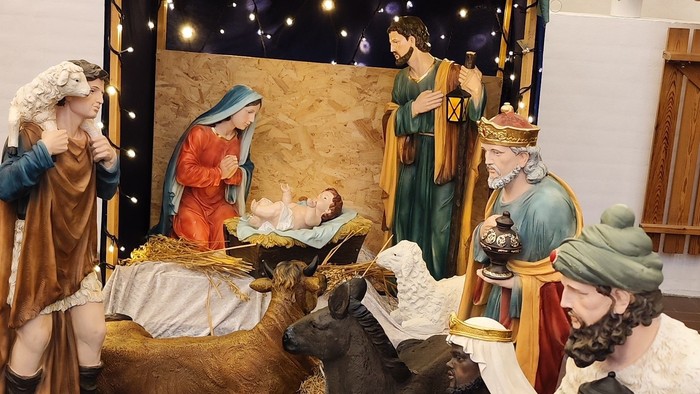En julekreds med Jesusbarn, Maria, Josef og andre figurer i en stabel med hest og okse.