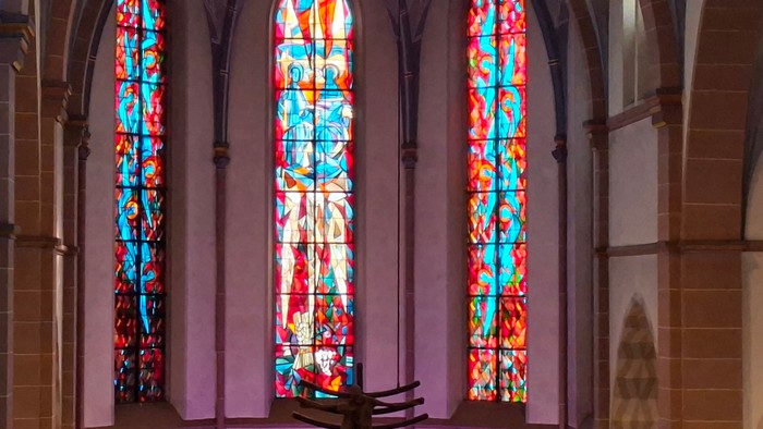 Die Buntglasfenster erhellen das friedvolle Kircheninnere mit leuchtenden Farben und religiösen Motiven.