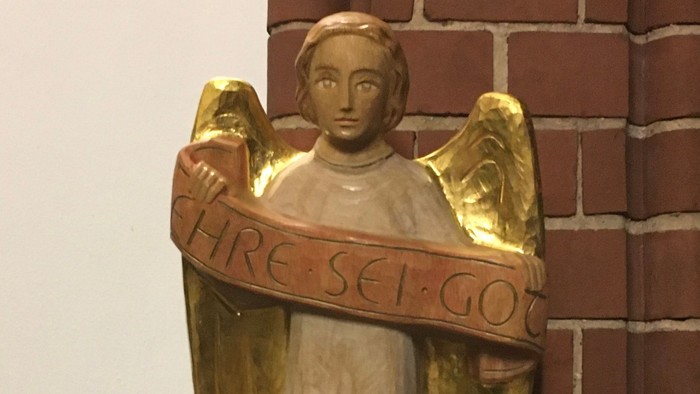 Engel mit Schriftband an Ziegelmauer