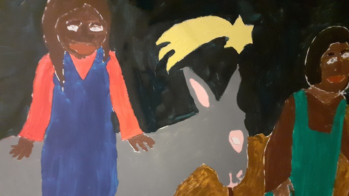 Ein Kind reitet auf einem Esel, während zwei weitere Kinder daneben gehen