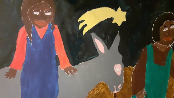 Ein Kind reitet auf einem Esel, während zwei weitere Kinder daneben gehen