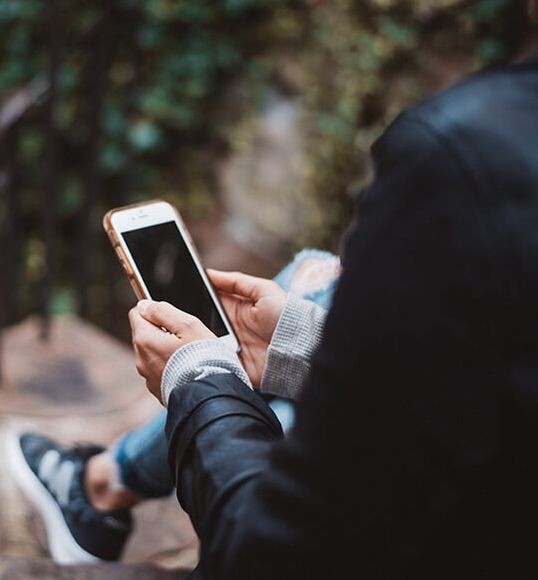 Person schaut auf Handy Person schaut auf Handy
