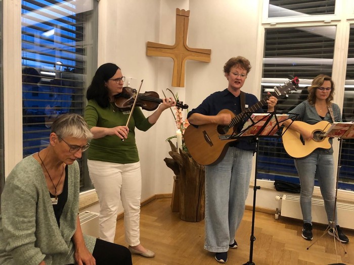 Vier Musikerinnen vor Holzkreuz in einer Raumecke