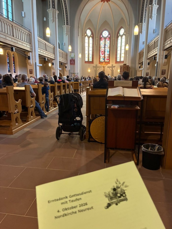 Volle Kirche an Erntedank 2026; im Vordergrund das Liedblatt