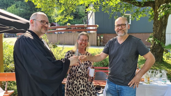 Michaela und Bernd stoßen mit Pfarrer Stefan Geil nach der feierlichen Zeremonie auf ihre Segnung an. (Foto: Klaus Kordesch /eöa)