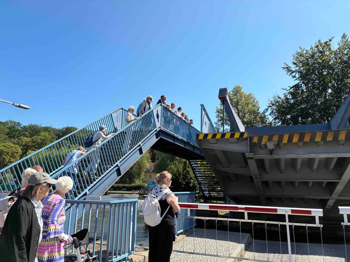 Die Woltersdorfer Schleuse senkt sich und einige Menschen schauen zu