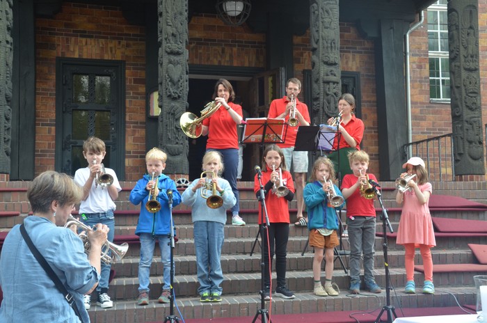 Junge Kinder spielen Blechblasinstrumente auf der Treppe der Kirche