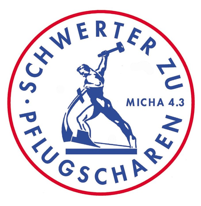 Das Logo zeigt einen Schmied mit Hammer und Amboss, umgeben von Text in Blau und Rot