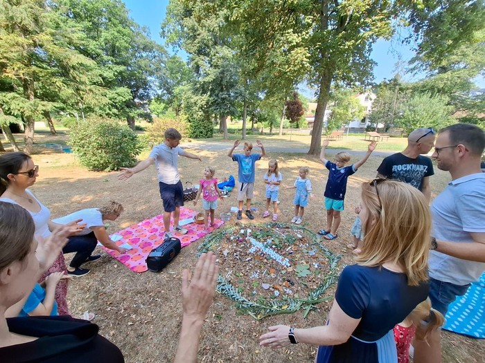 Kinderkirche im Grezzbachpark Kinder mit Kreuz aus Blumen