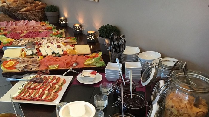 Ein Buffettisch mit verschiedenen Käsesorten, Wurst, Brot und Getränken