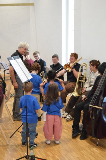 Kinder und Orchestermusiker*innen musizieren