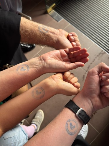 Vier Arme mit einem Segensstempel aus dem Gottesdienst mit Reisesegen