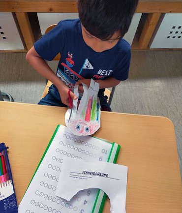 Eine Ausschneideübung bei der Sommerschule 2023. Ein Angebot der Kita-Sozialarbeit im Kirchenkreis Spandau.