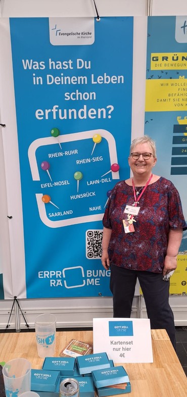 Eine Frau mit rotem Band und Namensschild vor einem blauene Rollup und der Frage: Was hast Du in Deinem Leben schon erfunden? Eine Frau mit rotem Band und Namensschild vor einem blauene Rollup und der Frage: Was hast Du in Deinem Leben schon erfunden?