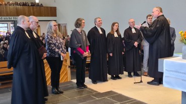 Auch das nunmehr vollständige Verkündigungsteam erhielt von Dekan Friedrich den Segen zugesprochen (v.li.): Pfarrer Felix Heinz, Pfarrer Dr. Reiner Braun, Dekanatskirchenmusikerin Rut Hilgenberg, Gemeindepädagogin Katharina Lutz, Pfarrer Jörg Voget, Pfarrerin Susanne Scherer, Pfarrer Siegfried Schmidt, Gemeindepädagoge Robin Feldhaus und Gemeindepädagogin Kerstin Griesing (verdeckt). (Foto: Klaus Kordesch /eöa) Auch das nunmehr vollständige Verkündigungsteam erhielt von Dekan Friedrich den Segen zugesprochen (v.li.): Pfarrer Felix Heinz, Pfarrer Dr. Reiner Braun, Dekanatskirchenmusikerin Rut Hilgenberg, Gemeindepädagogin Katharina Lutz, Pfarrer Jörg Voget, Pfarrerin Susanne Scherer, Pfarrer Siegfried Schmidt, Gemeindepädagoge Robin Feldhaus und Gemeindepädagogin Kerstin Griesing (verdeckt). (Foto: Klaus Kordesch /eöa)