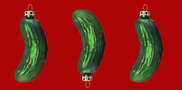 3 Christbaum-Anhänger in Form von grünen Gurken auf rotem Hintergrund