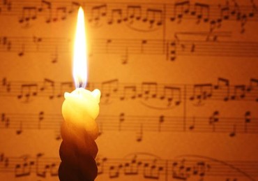 Brennende Kerze vor Noten