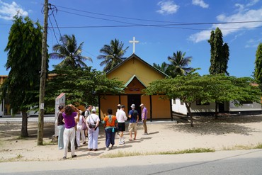 Mehrere Menschen stehen vor einer Kirche in Tansania