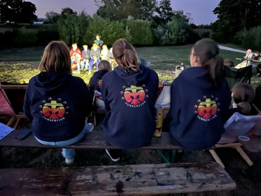 Zuschauer beim Bunten Abend mit Aufführung im Hintergrund