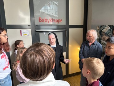 Eine Schwester mit Jugendlichen an einer Babyklappe, von der Sternstraße immer erreichbar