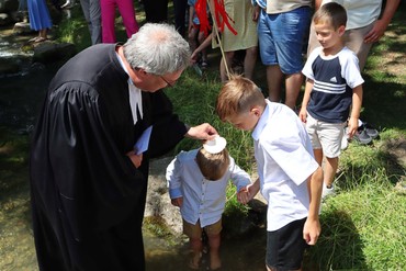Pfarrer Walter tauft einen Jungen (Foto: Axel Langer)