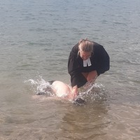 Pfarrerin tauft Jungen im Straberger See